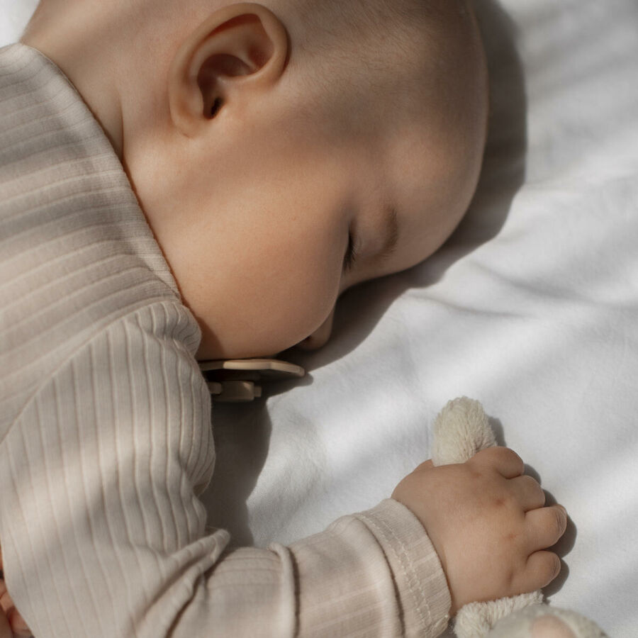Imagem bebe dormindo com travesseiro chupeta e ursinho
